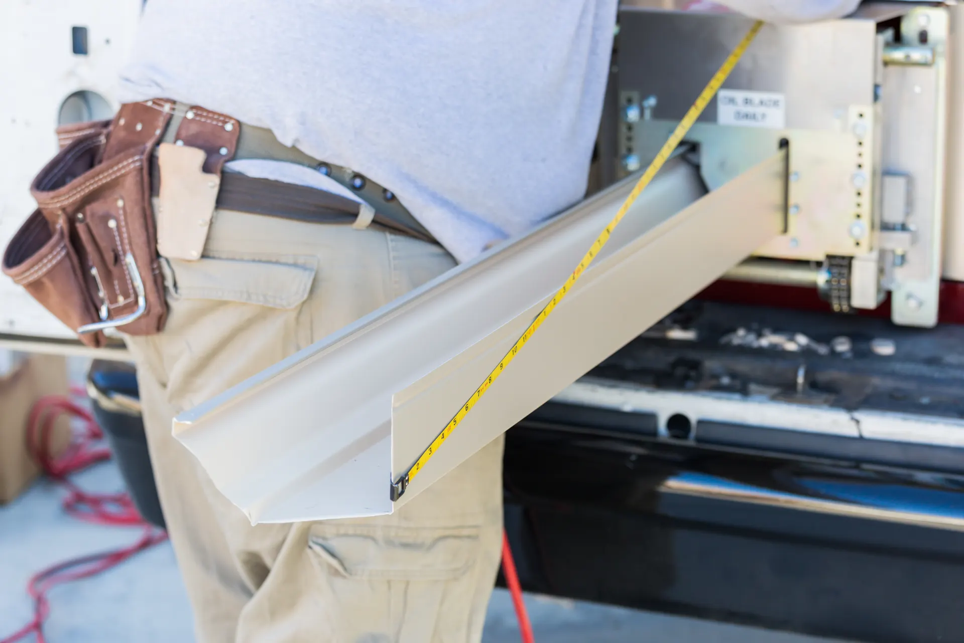 Gutter professional measuring a seamless gutter run